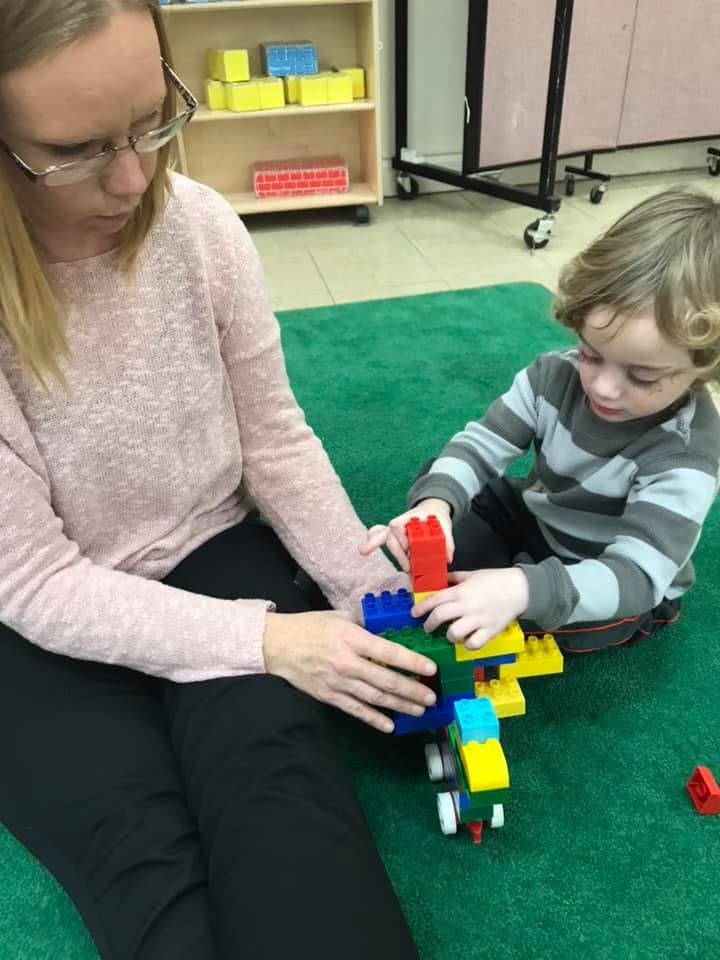 Person and child building with colorful blocks