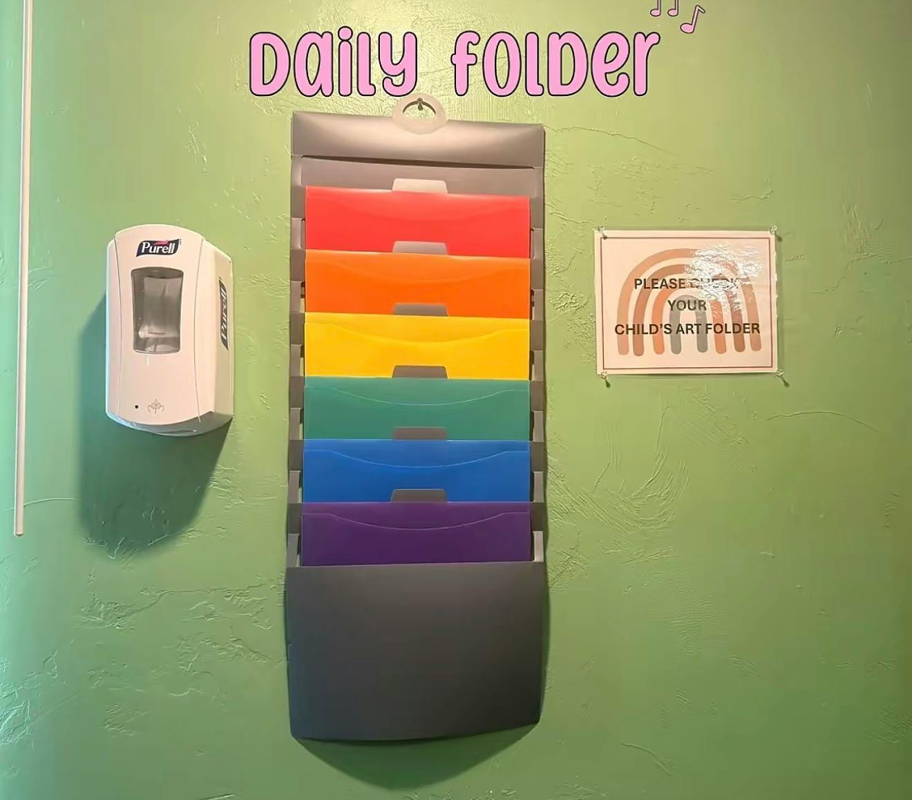 Daily folder sign above rainbow folders and a hand sanitizer dispenser