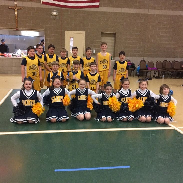 Group of children in basketball uniforms and cheerleading outfits