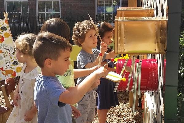 Children playing with outdoor musical instruments