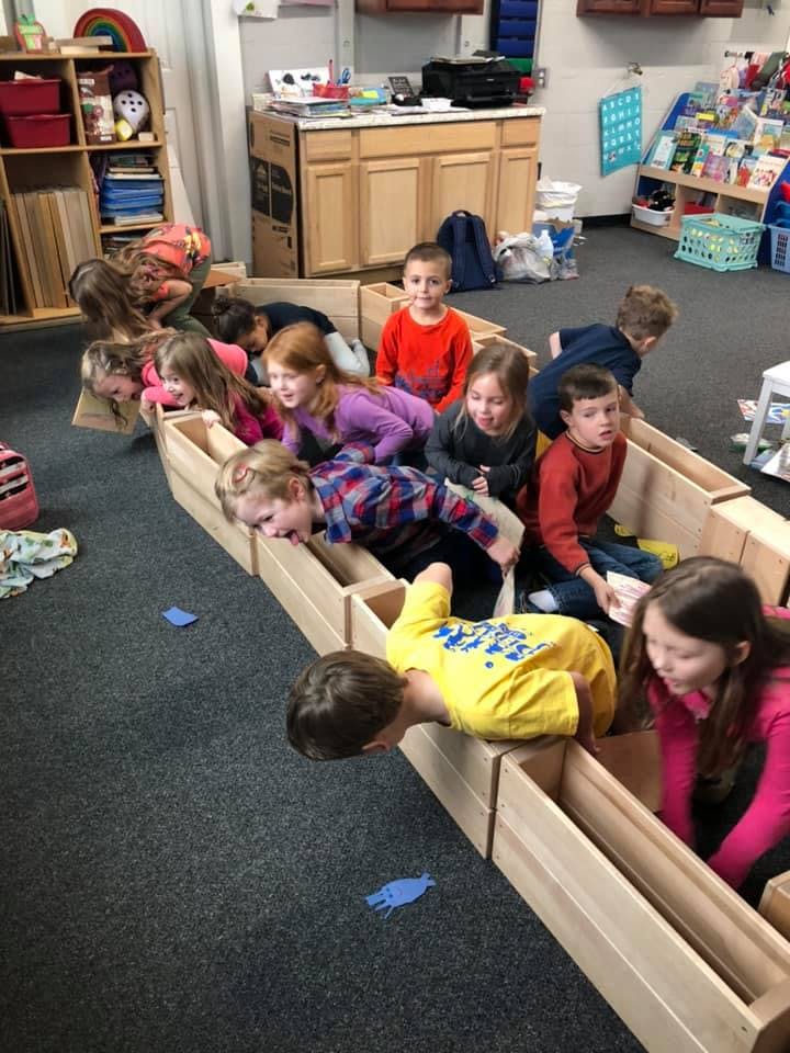 Children playing with wooden blocks in a classroom