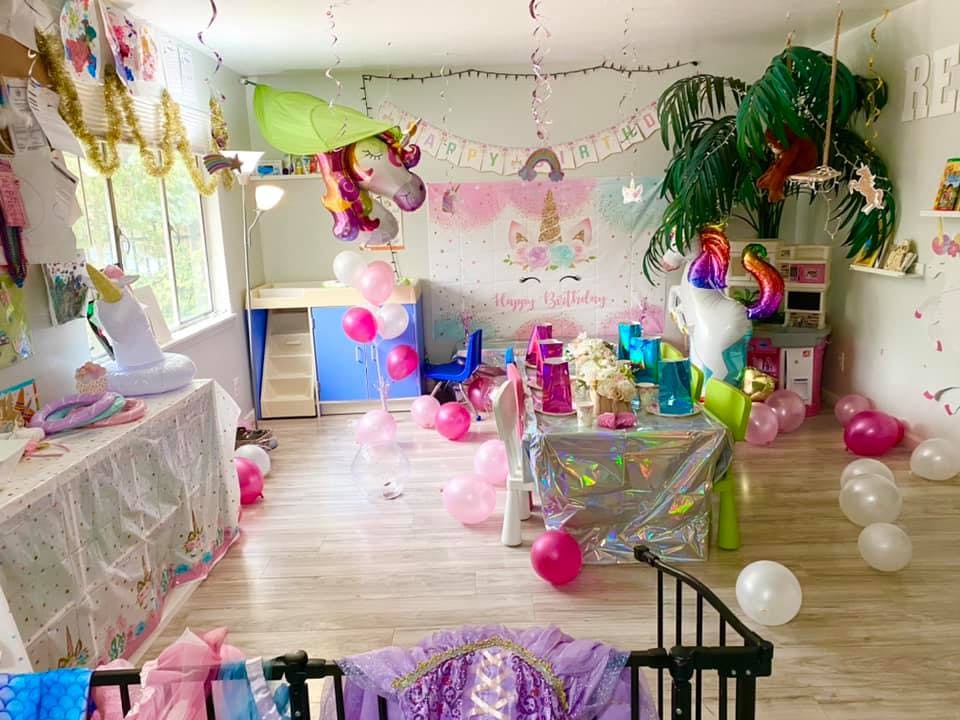 Room decorated with unicorn-themed party decorations and balloons