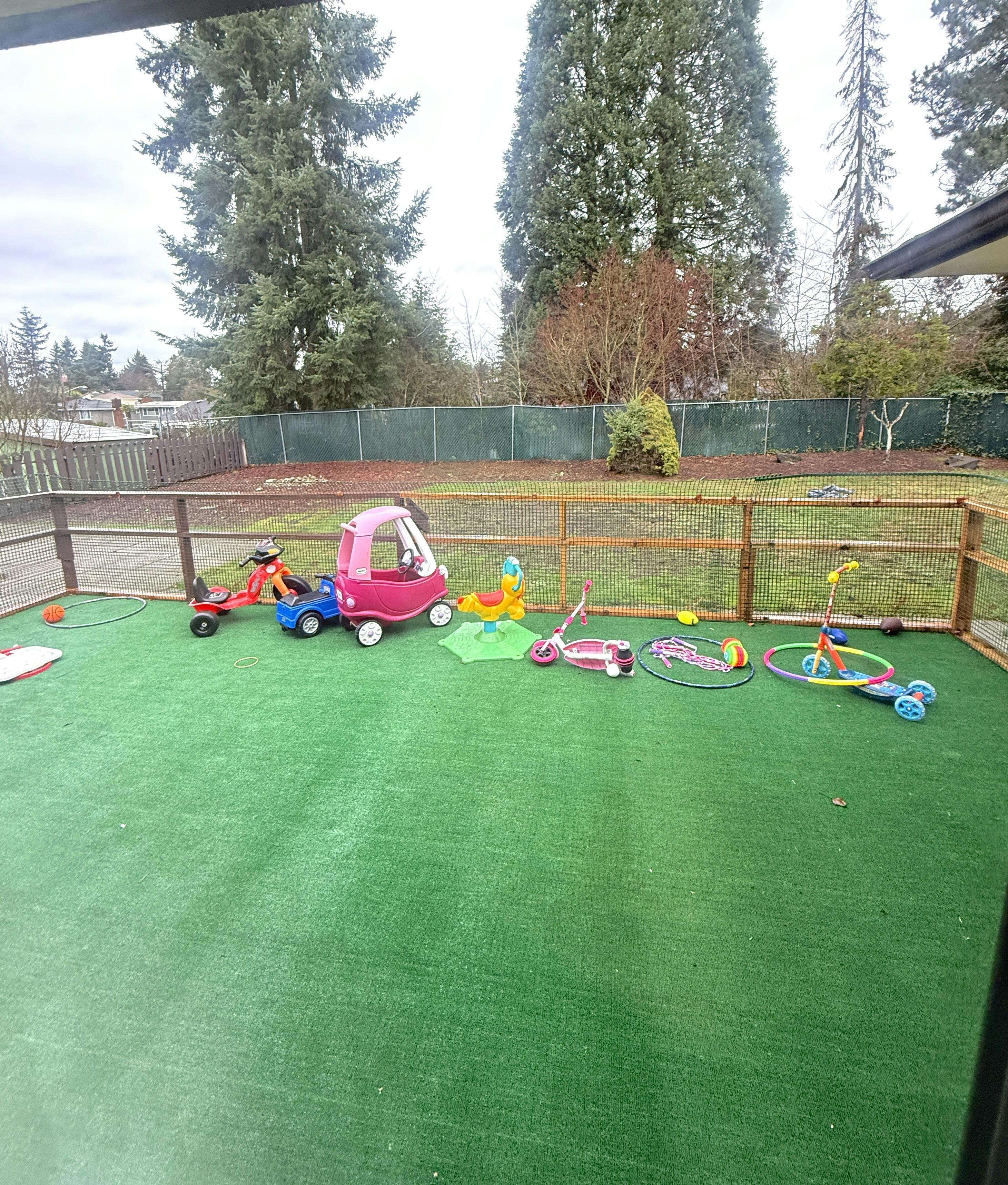 Collection of children's ride-on toys and equipment on an outdoor turf area