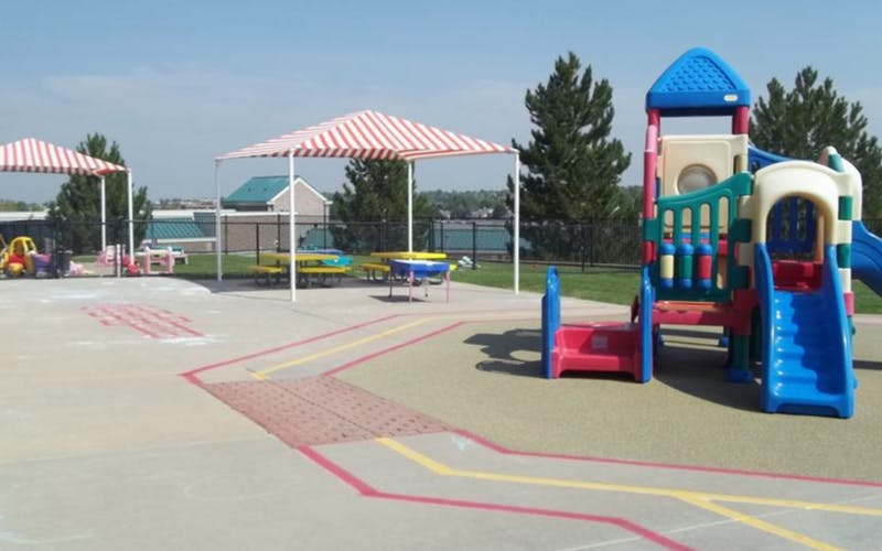 Outdoor children's playground with colorful play structure and striped shade covers
