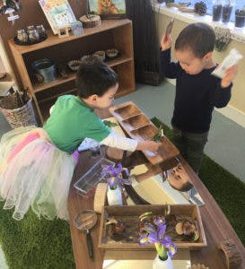 Two children playing with items on a table