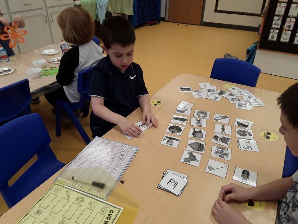 Children at a table sorting cards with images