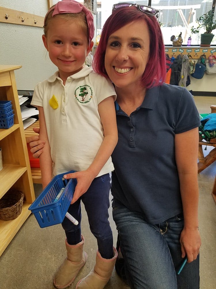 Adult and child standing together in a classroom