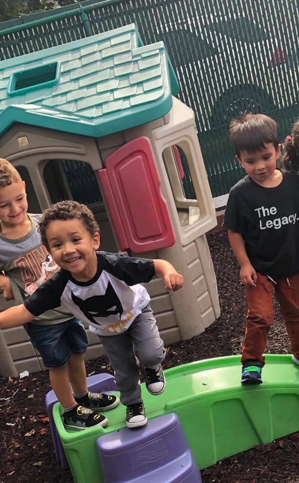 Three children playing on outdoor play equipment