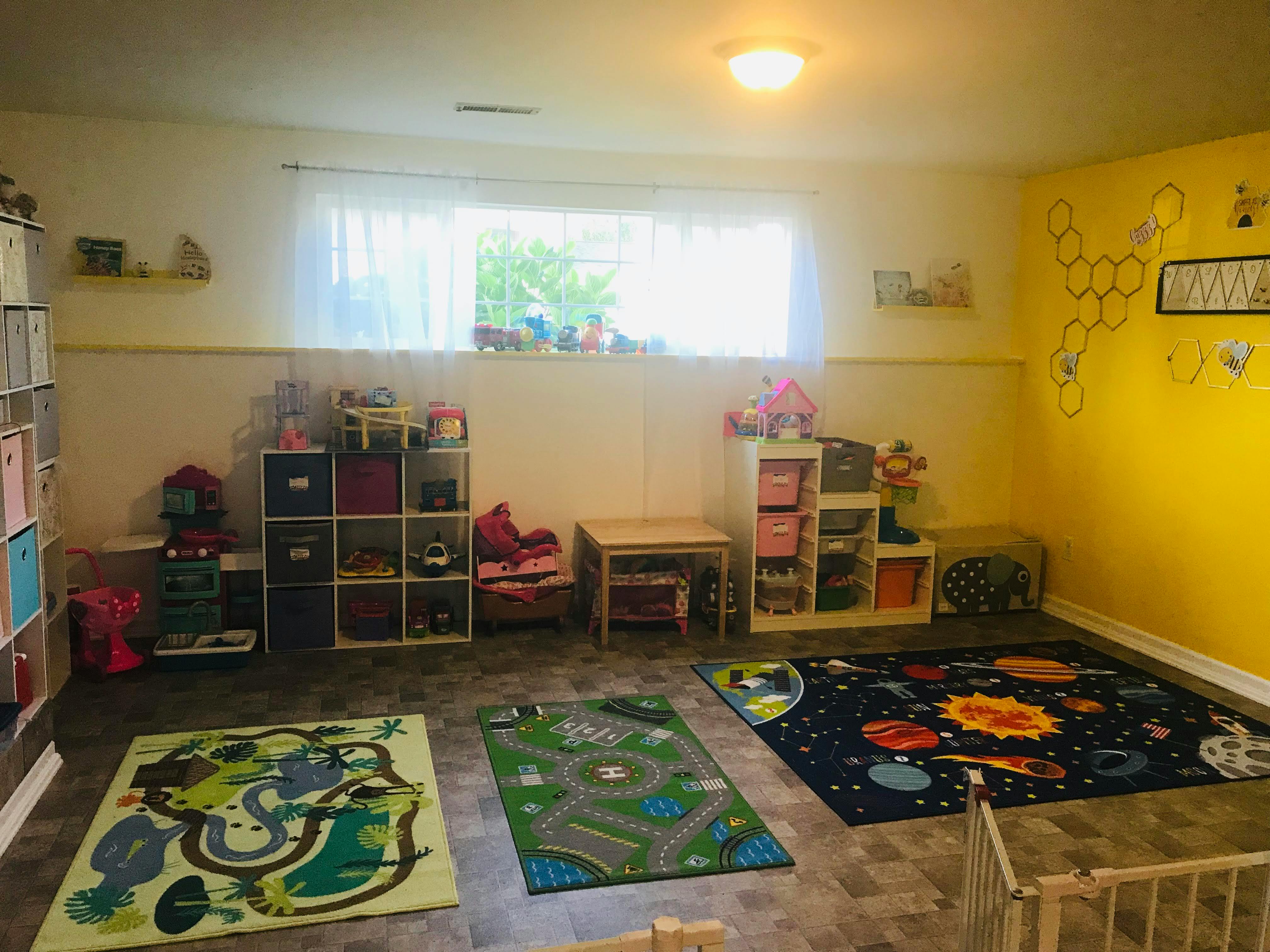 Playroom with colorful rugs, storage shelves, and a window