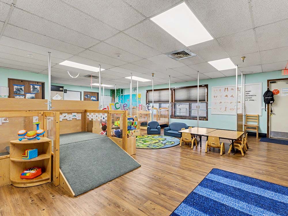 Playroom with a ramp leading to a platform and small tables and chairs
