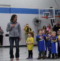 Adult and children standing in a gymnasium