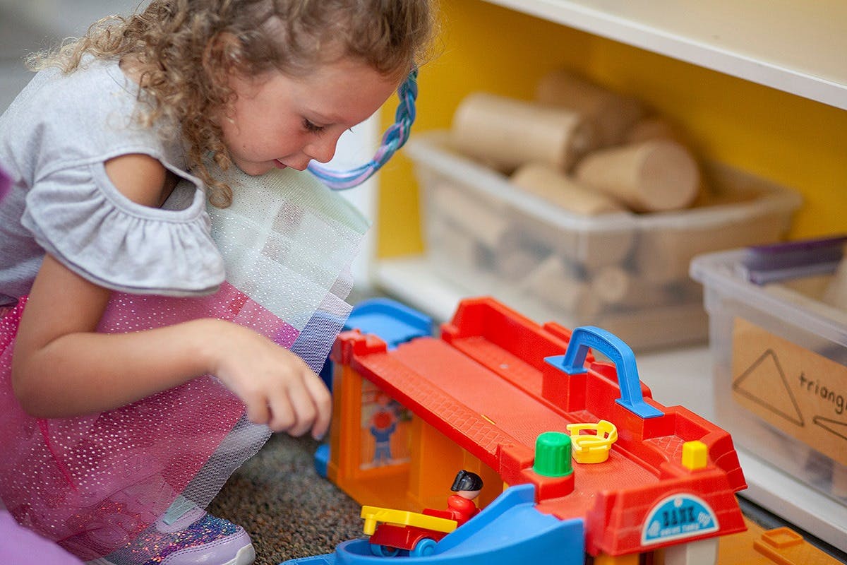 Child playing with a toy car ramp
