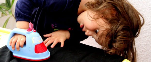 Child playing with a toy iron