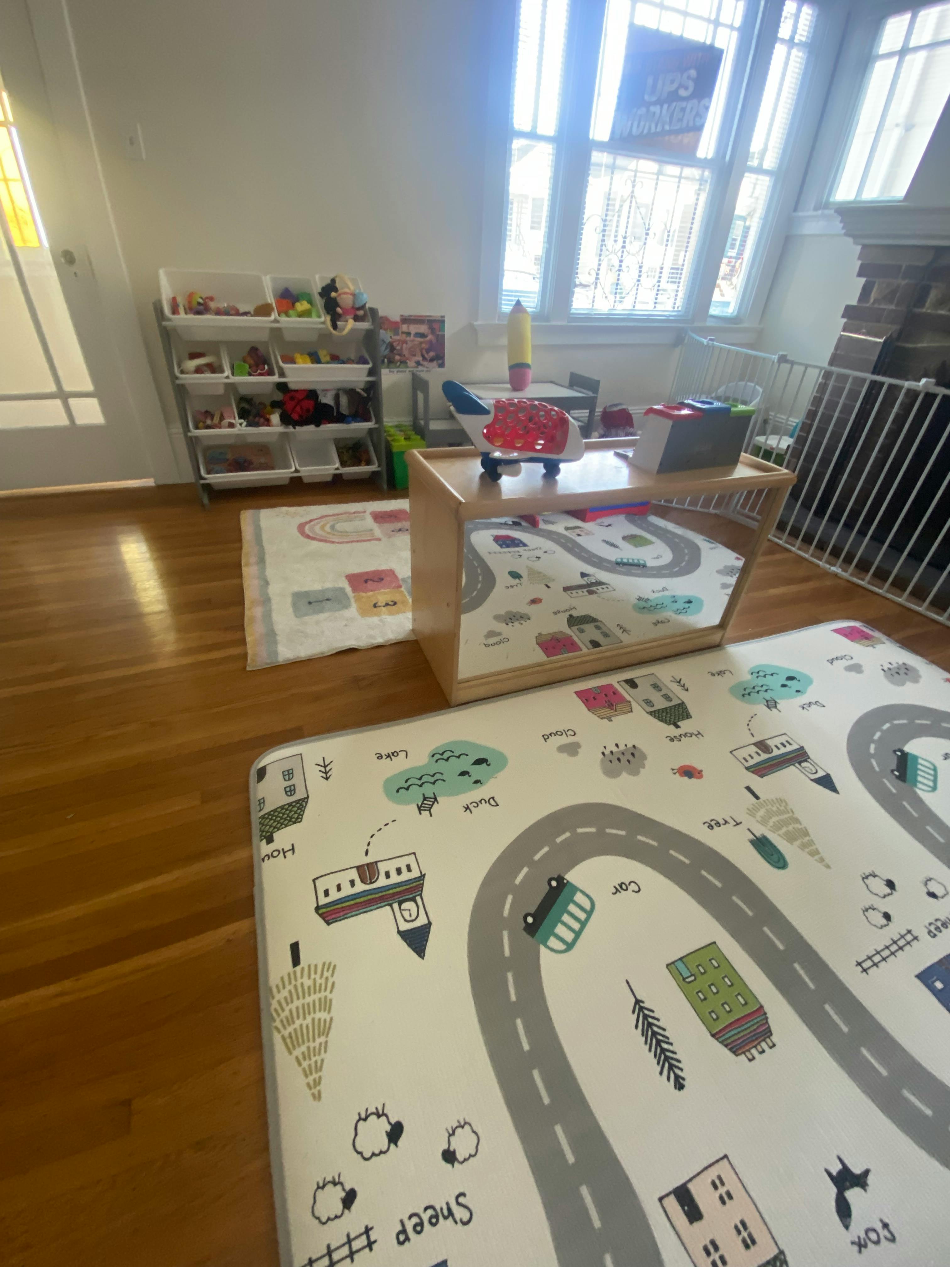 Playroom with toy storage, play mat, and small table with toys