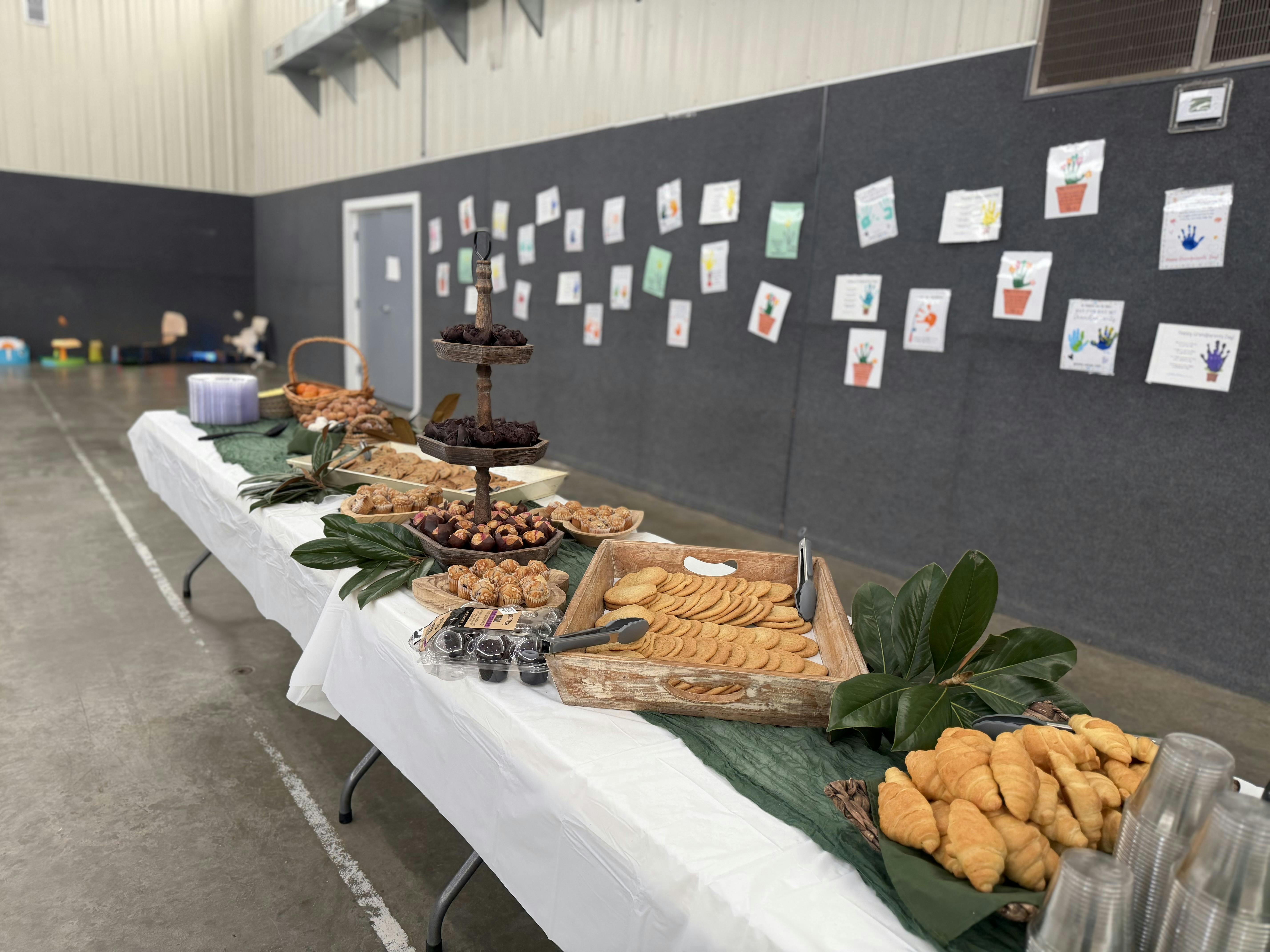 Catering table with tiered dessert displays, cookies, and croissants