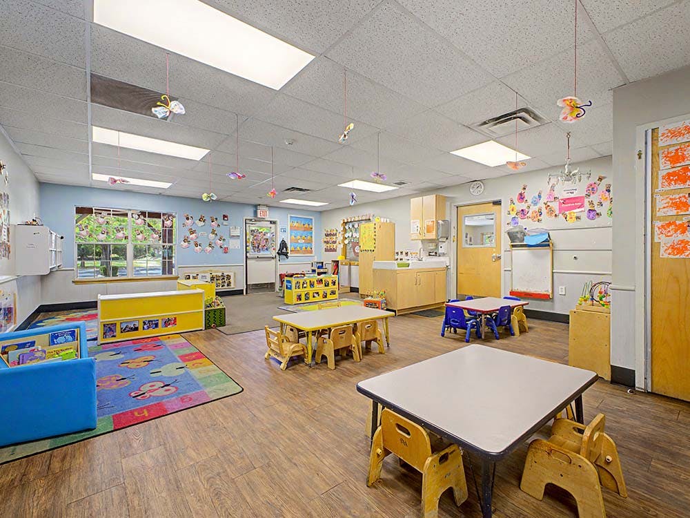 Empty colorful children's classroom with small tables and chairs
