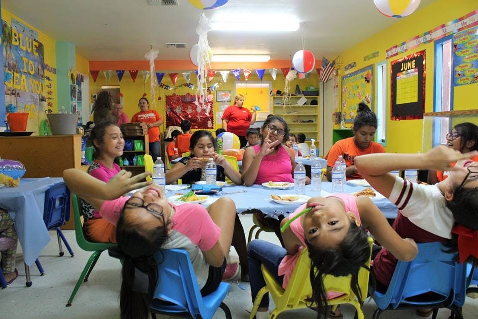 Children and teens sitting at tables in a classroom