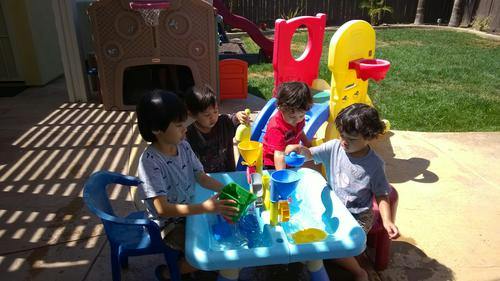 Children playing with a water table outdoors
