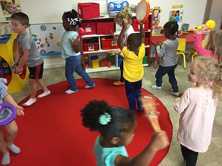 Children playing with musical instruments in a classroom