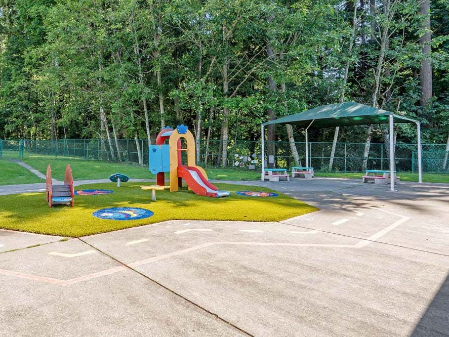 Colorful playground with small slide and green canopy overhanging canopy