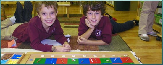 Two children lying on a rug with a learning toy