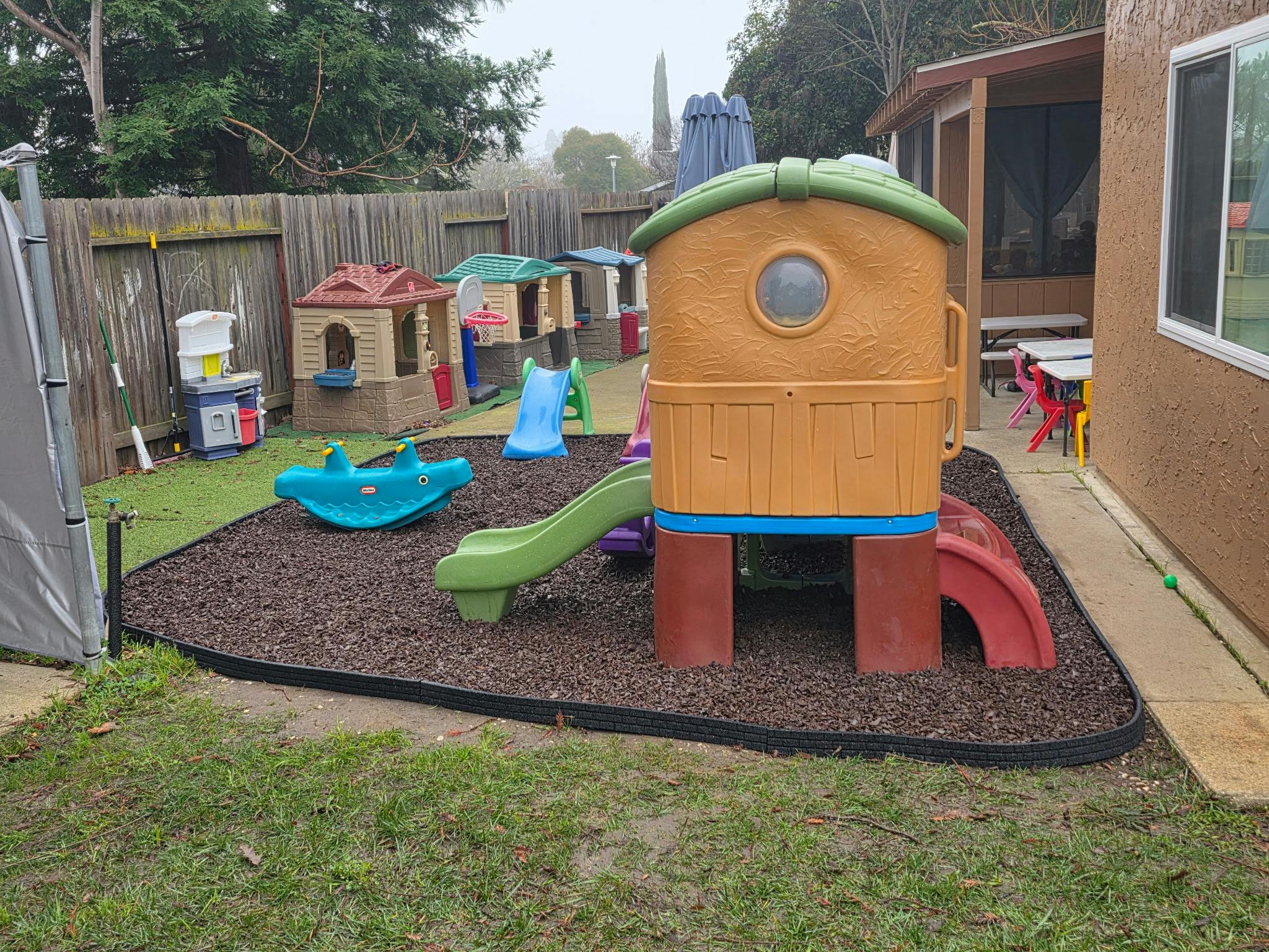 Children's playground equipment with plastic playhouses and slides in a backyard