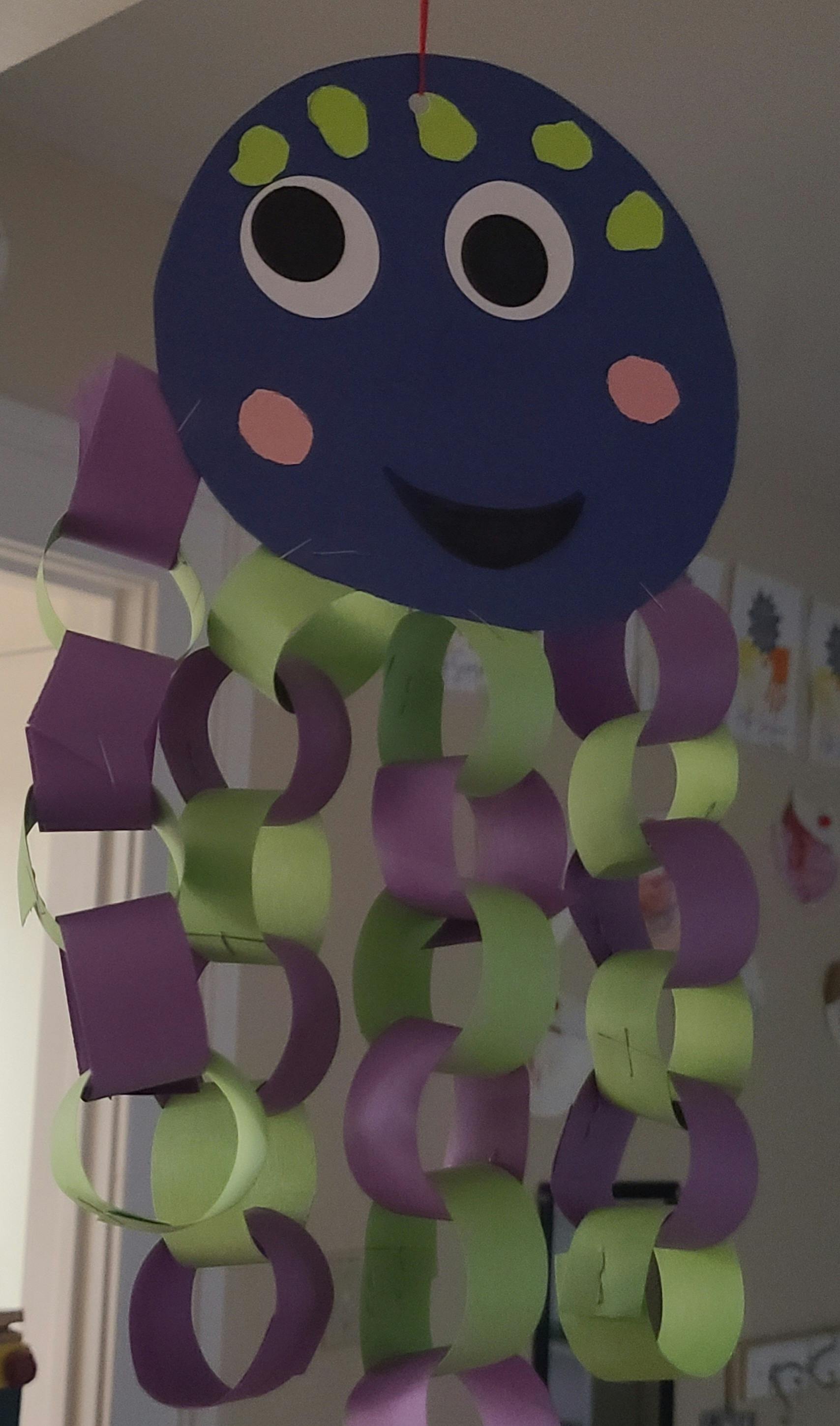 Paper craft octopus with purple head and green and purple chain tentacles