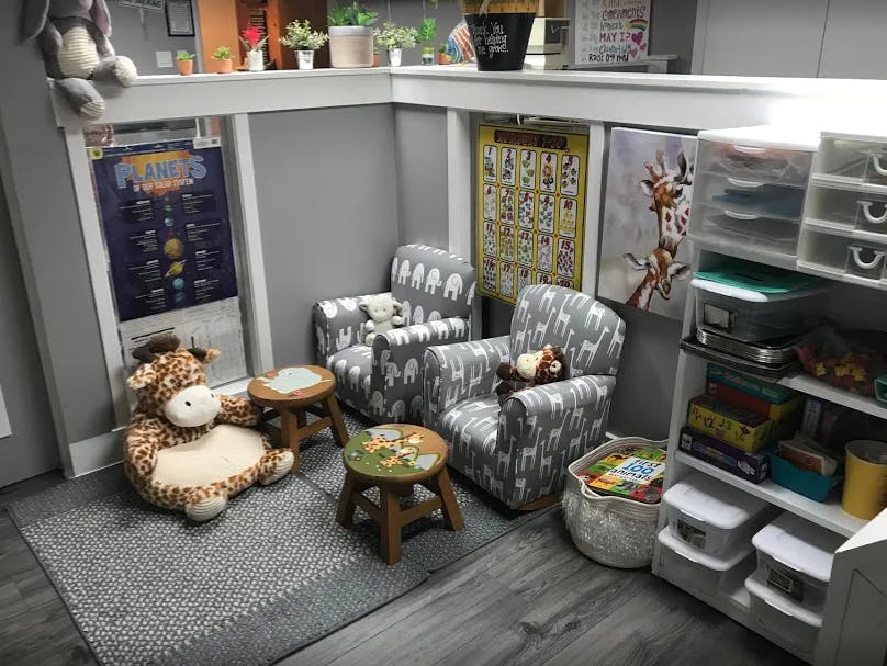 Two small armchairs and two small stools in a room with a stuffed animal