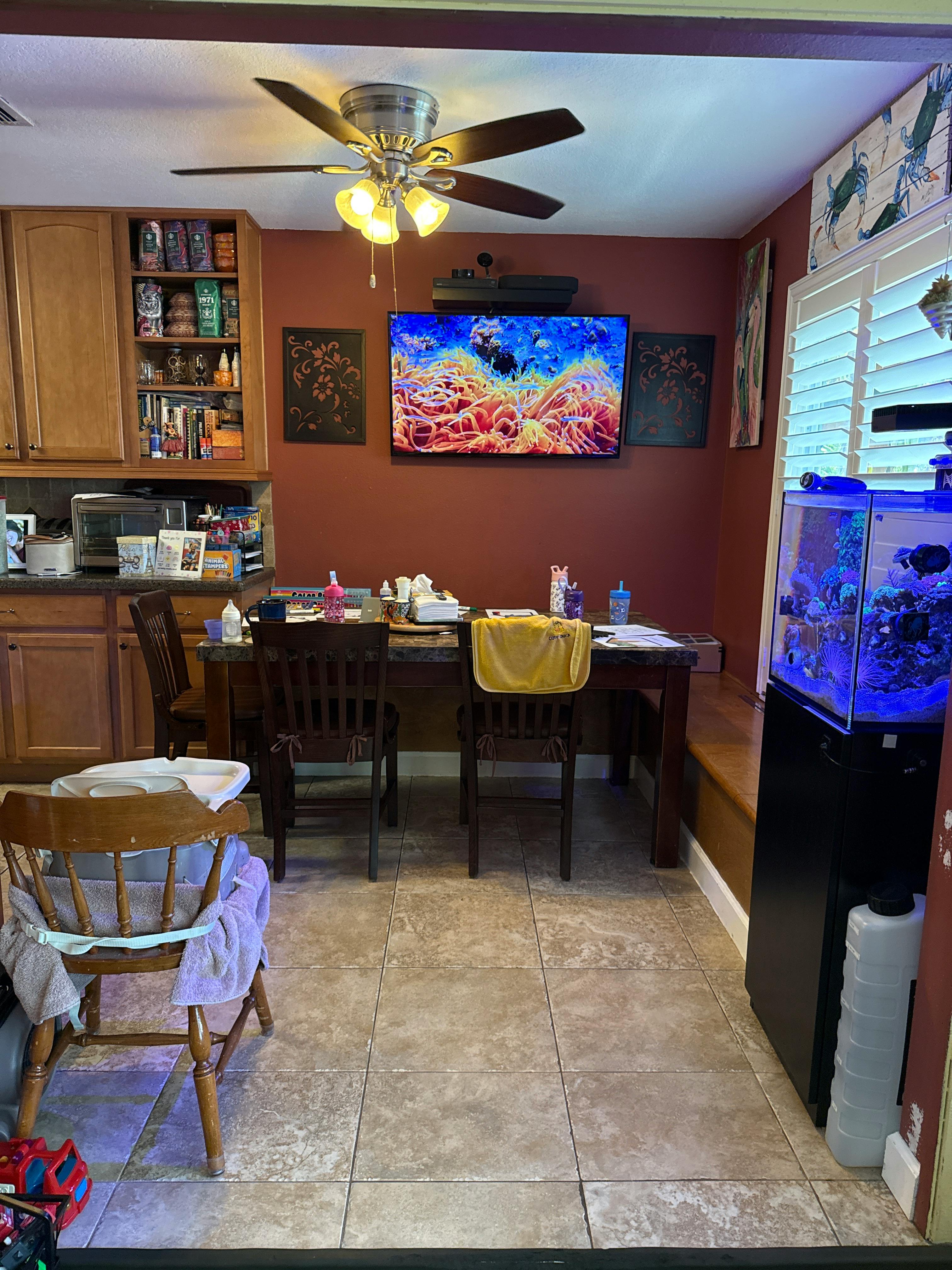 A dining area featuring a high table with chairs and an aquarium