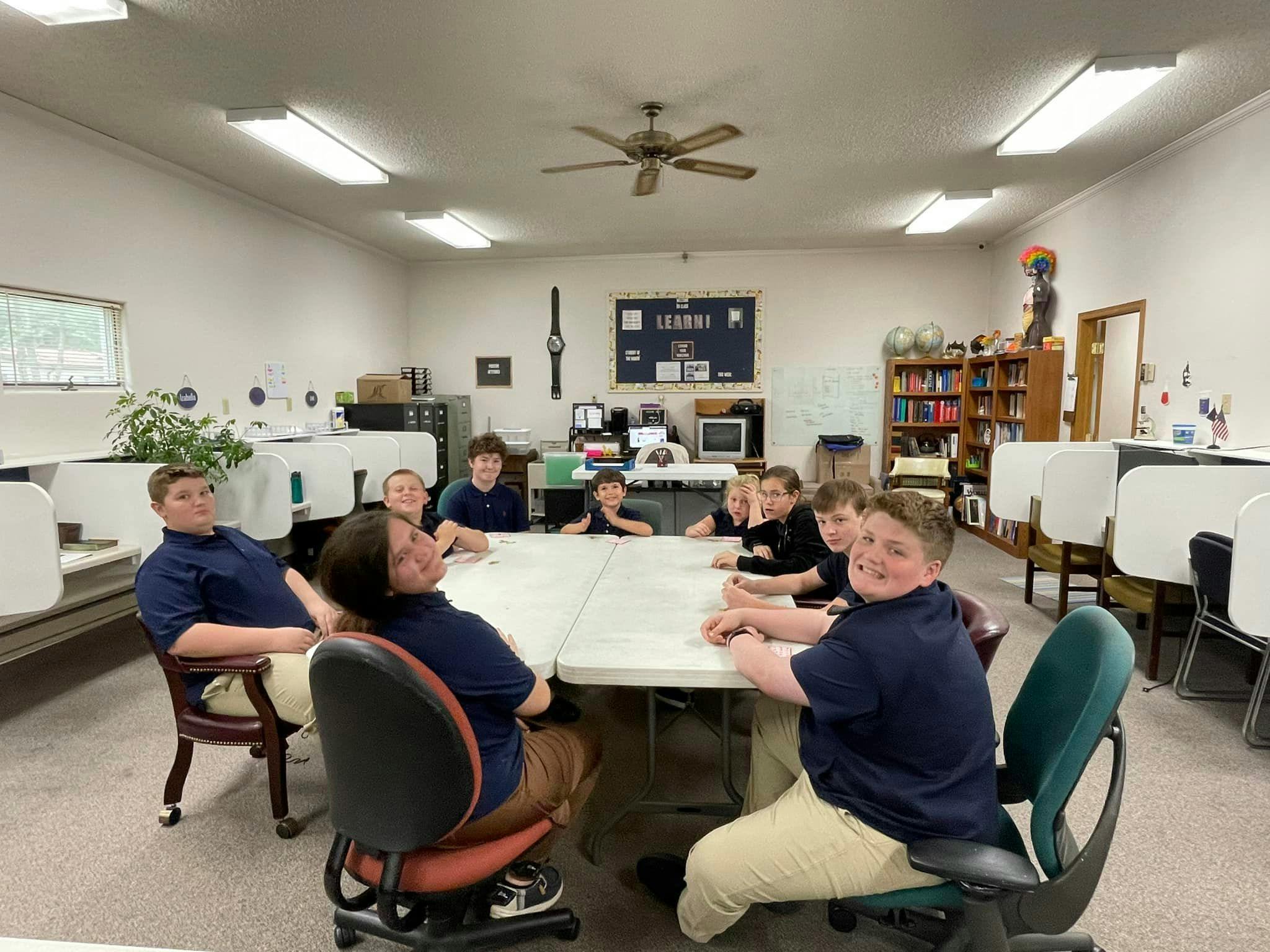Group of children and teens sitting at tables