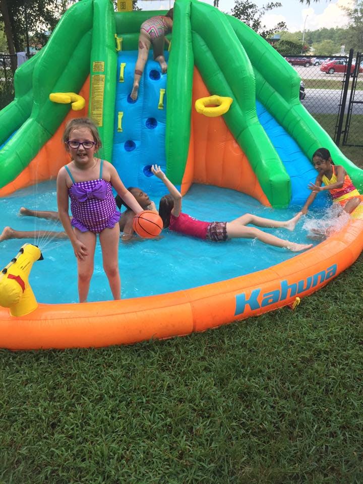 Children playing in an inflatable water slide and pool
