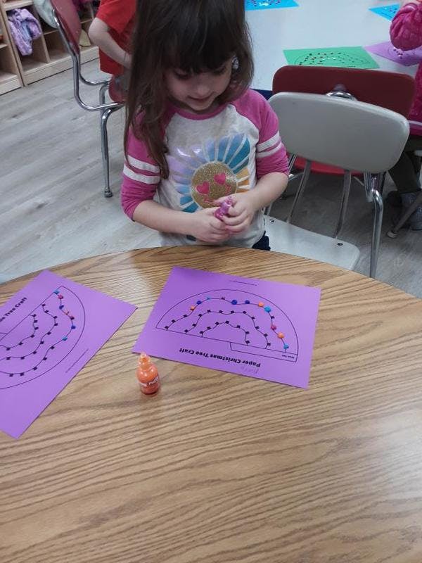 Child working on a craft project at a table