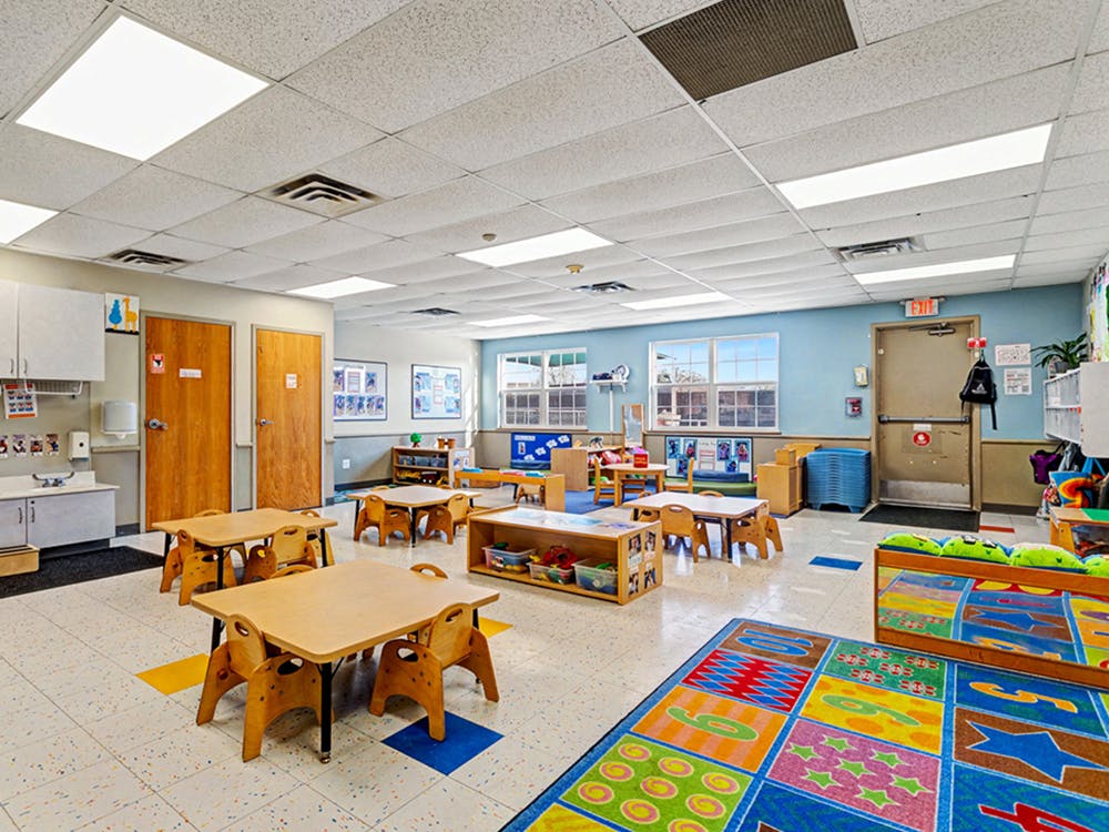Empty colorful children's classroom with small tables and chairs