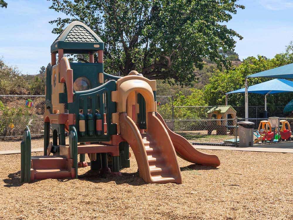 A children's playground with a large climbing structure and slide