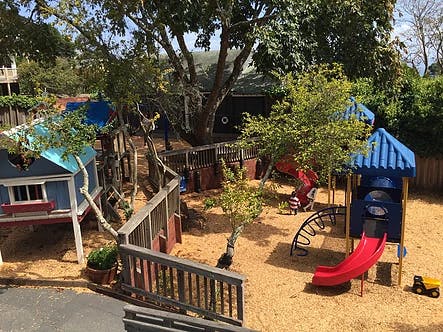 Outdoor playground with slides, play structures, and wood chips