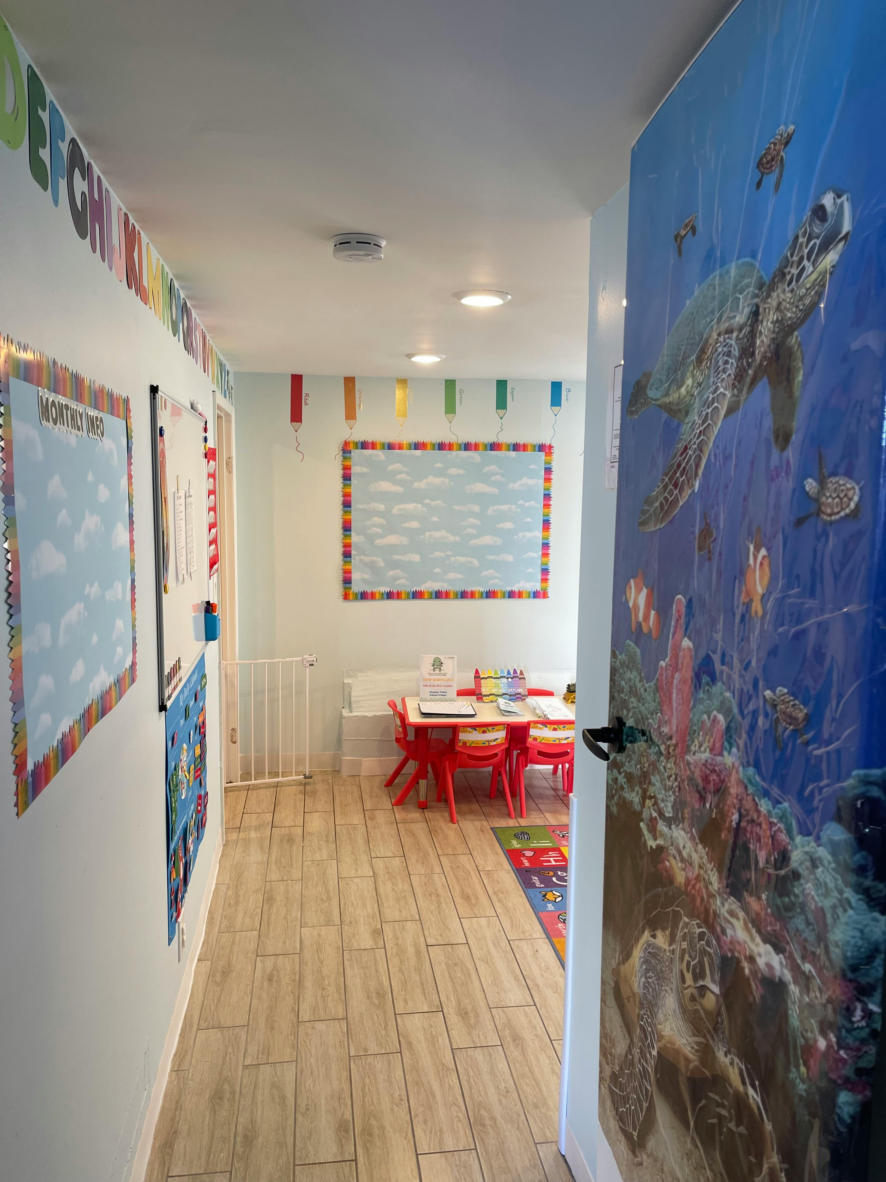 Hallway leading to a classroom with a table and chairs
