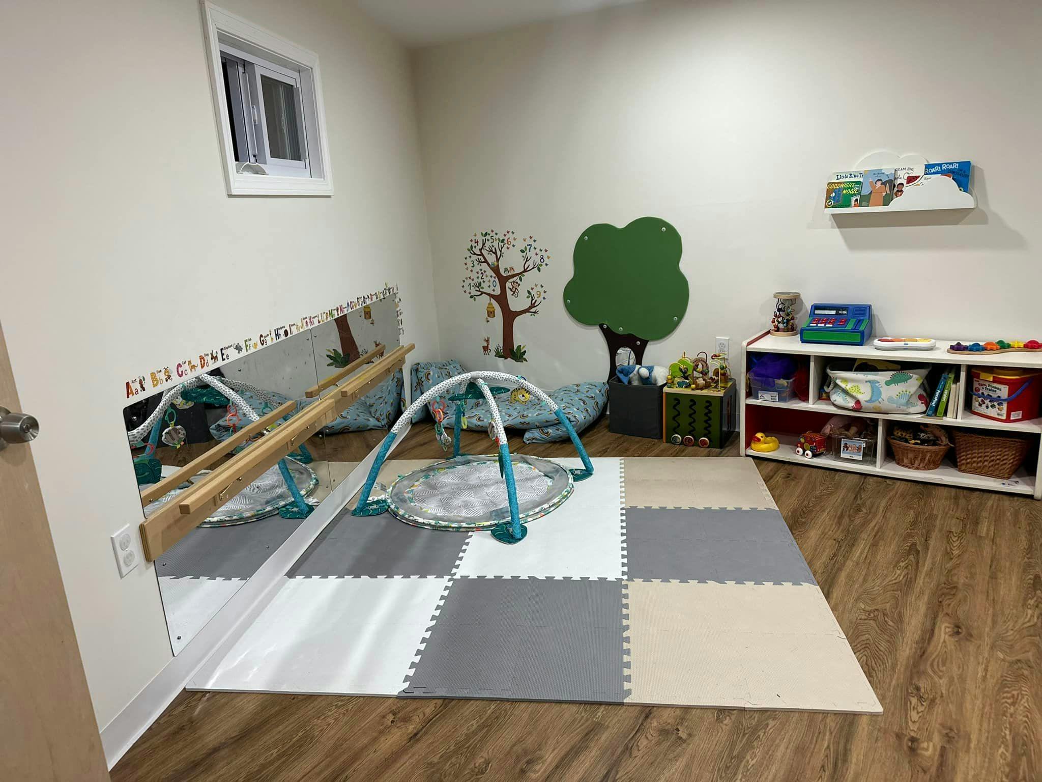 Playroom with soft floor tiles, baby gym, and toy shelves