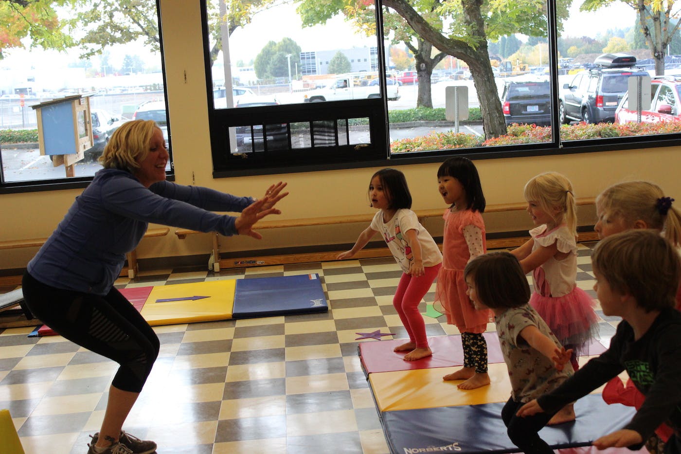 Adult and children doing squats in a room