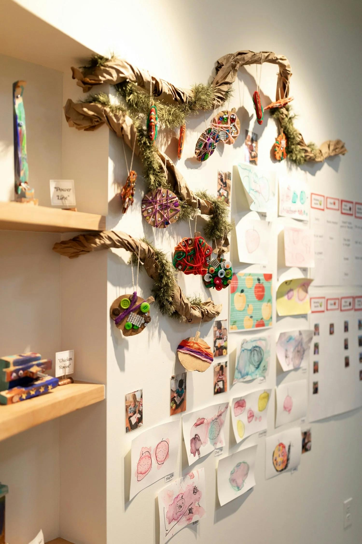 Craft ornaments and children's drawings displayed on a wall