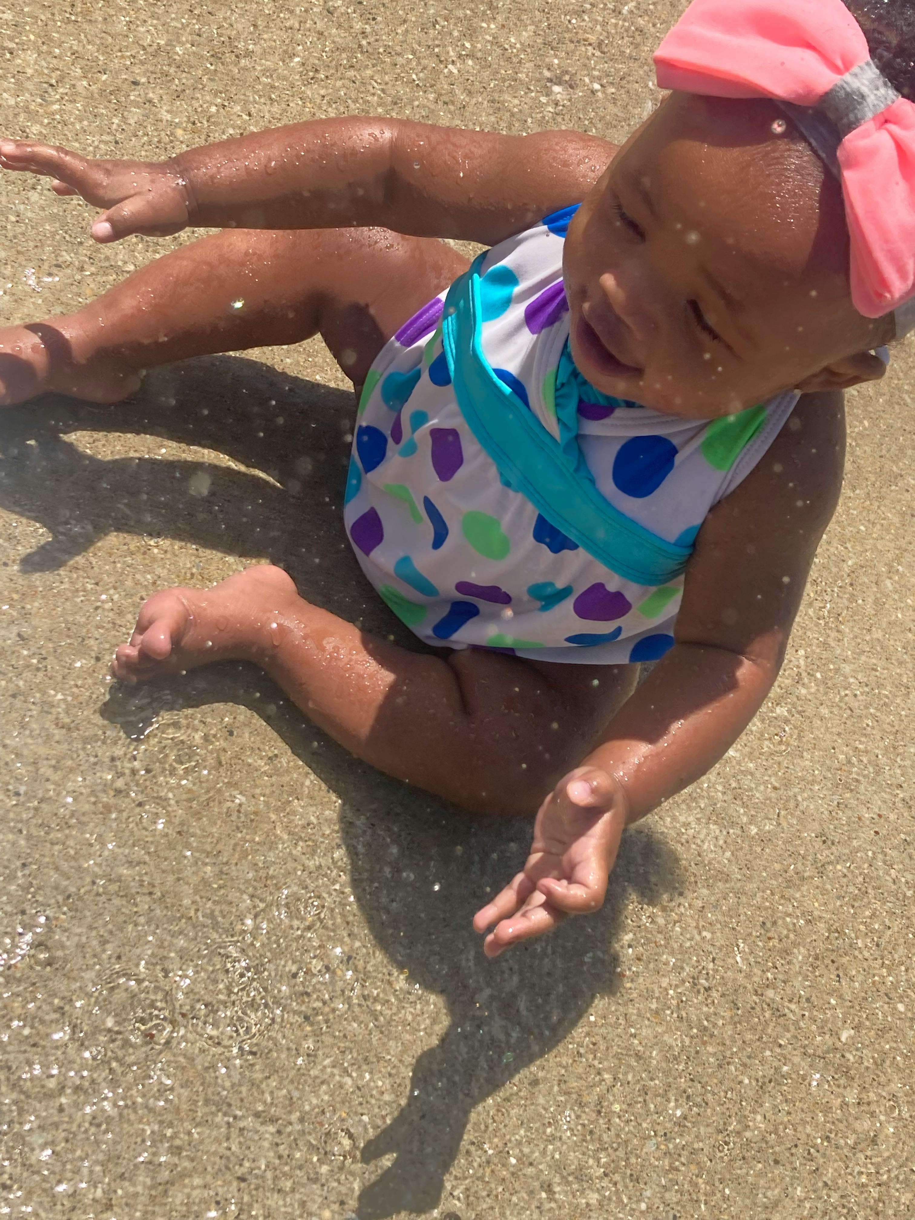Child sitting in shallow water
