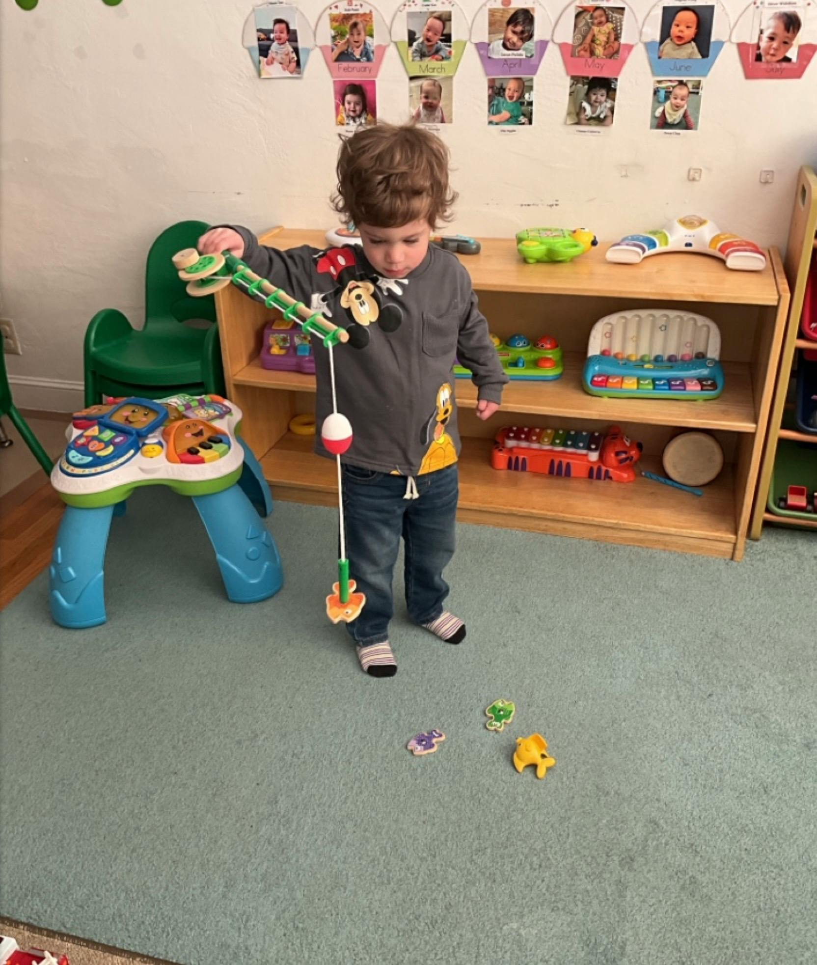 Child playing with a magnetic fishing toy in a classroom