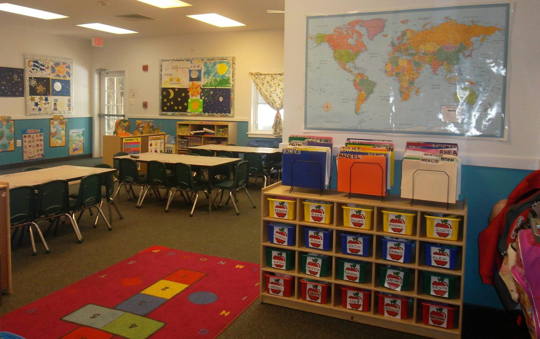 Classroom with tables, chairs, and a world map on the wall