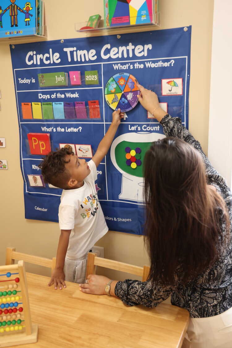 Adult and child interacting with a "Circle Time Center" calendar