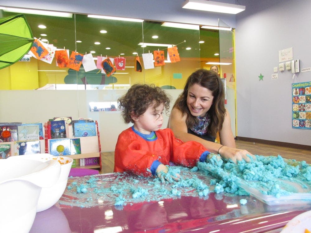 Adult and child playing with blue kinetic sand