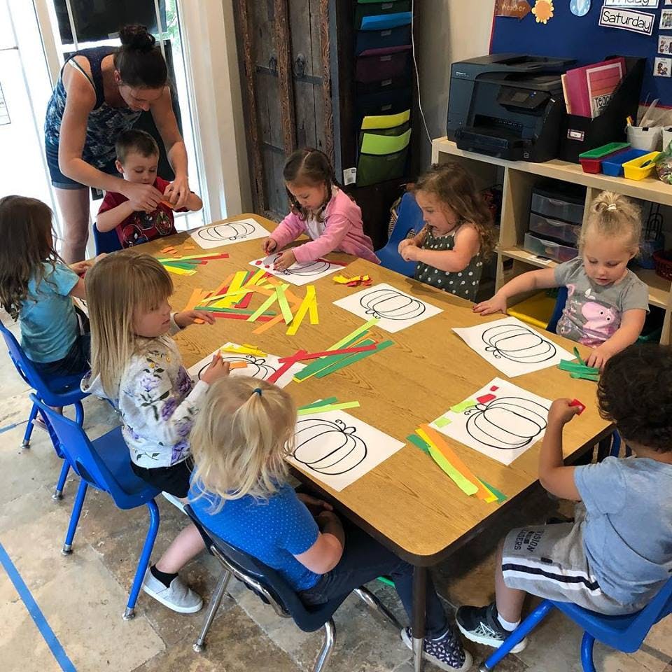 Adult and children doing crafts at a table
