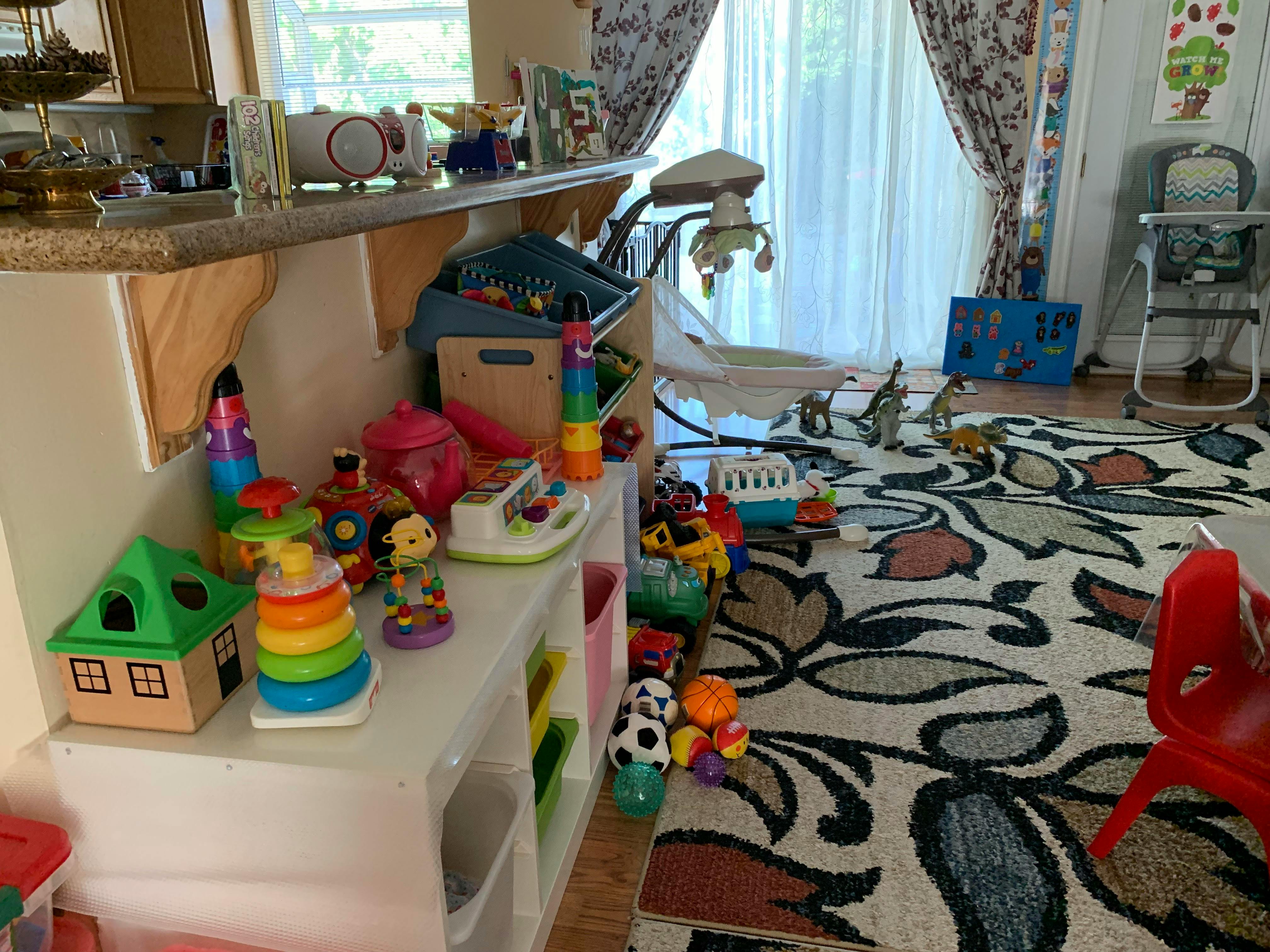 Children's toys on a shelf and scattered on a rug