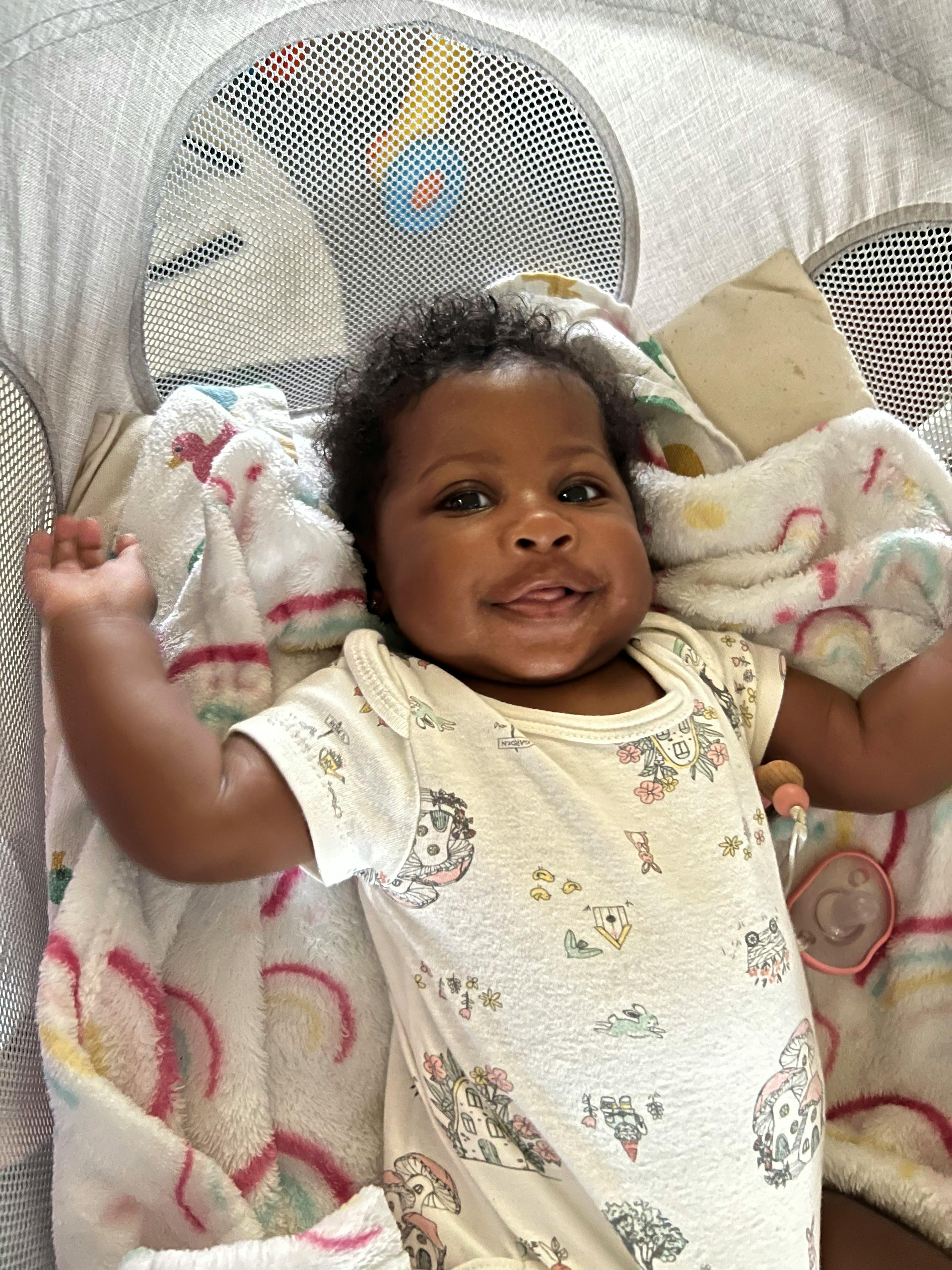 Child lying on back in a bassinet