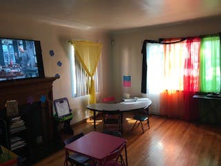 Living room with television, table, and colorful curtains