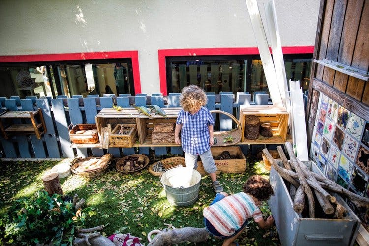 Two children playing outdoors with natural materials