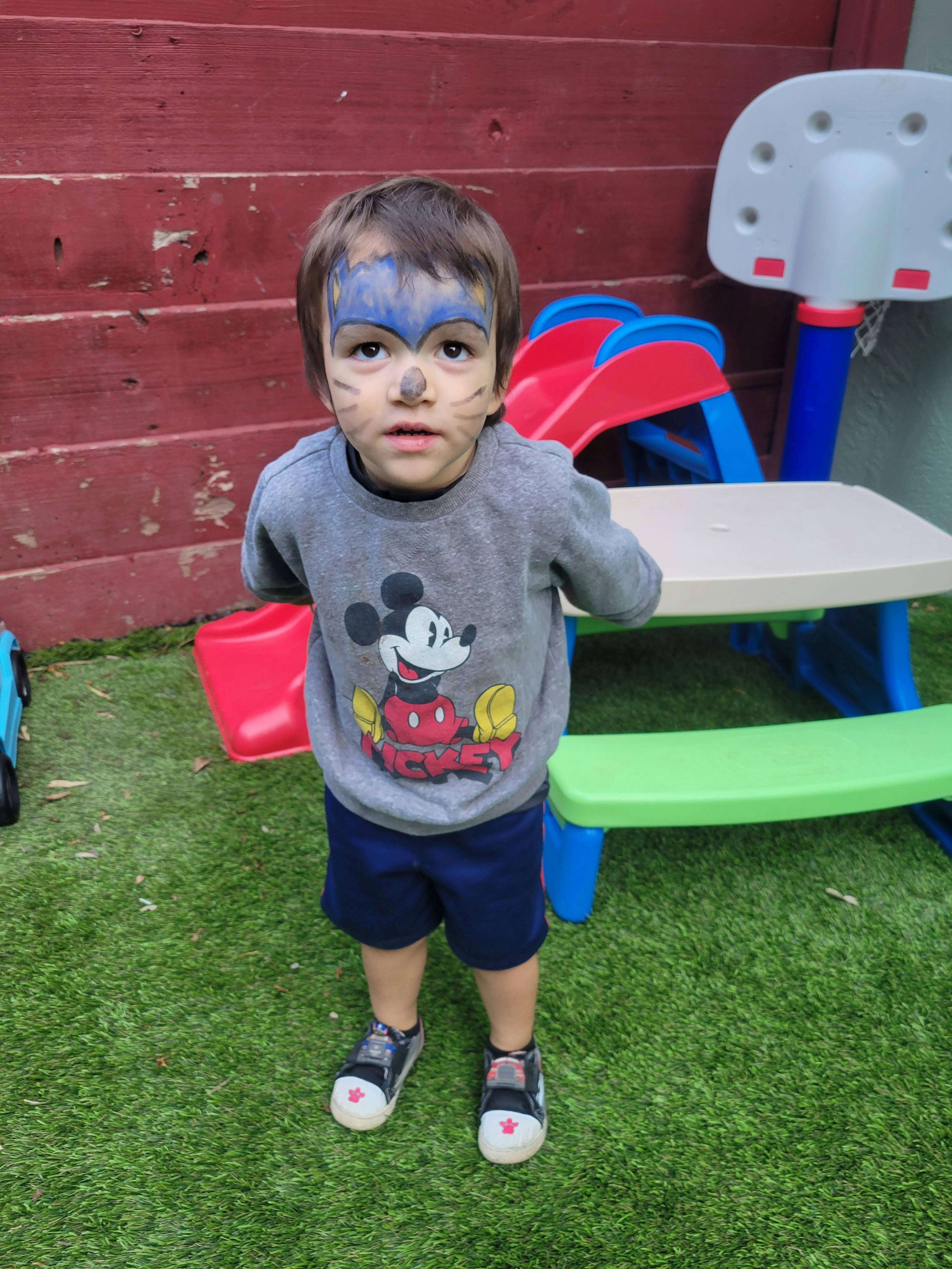 Child with face paint standing outdoors